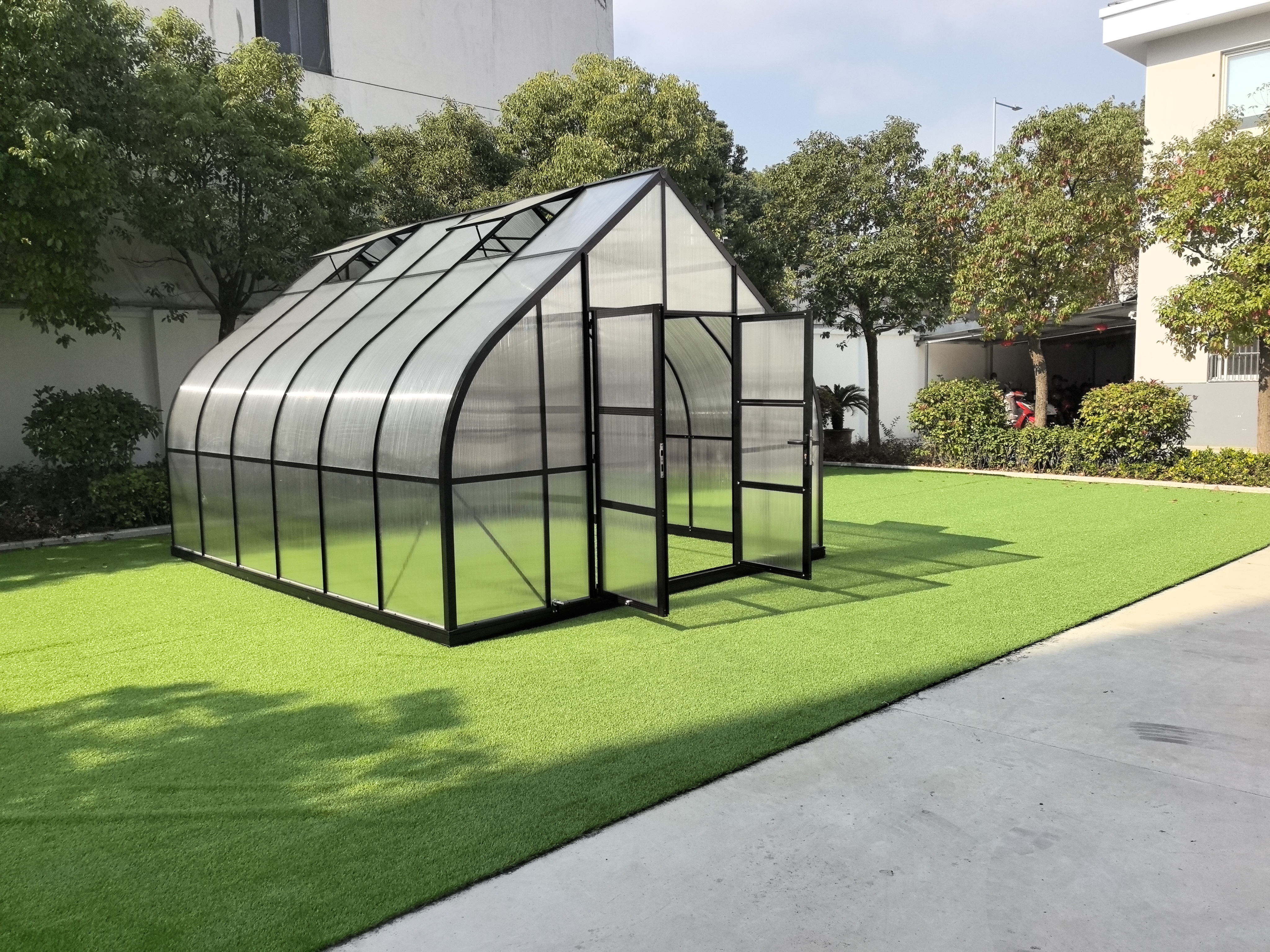 ClimaPod Magnum 12x14 greenhouse with open doors, revealing a spacious interior designed for efficient plant growth.