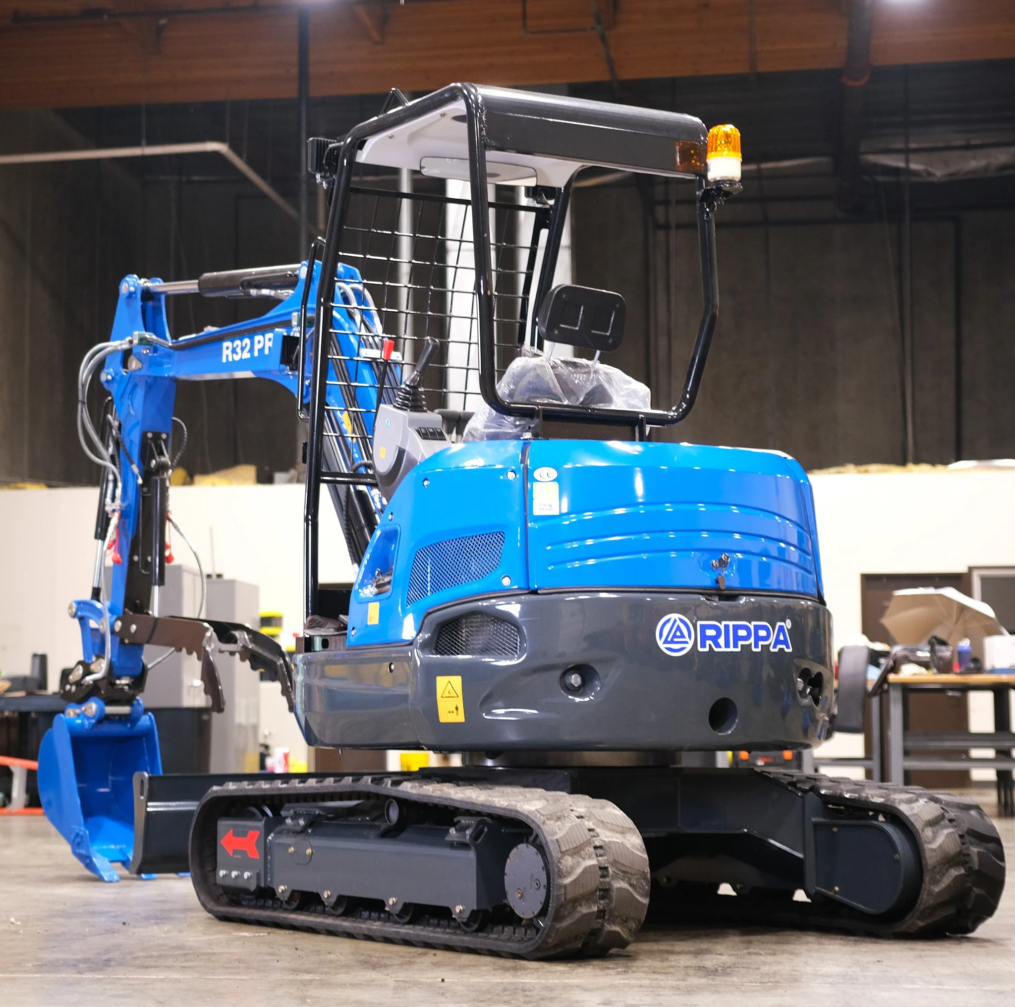 Rear-left profile of the R32 Pro compact excavator in the shop.