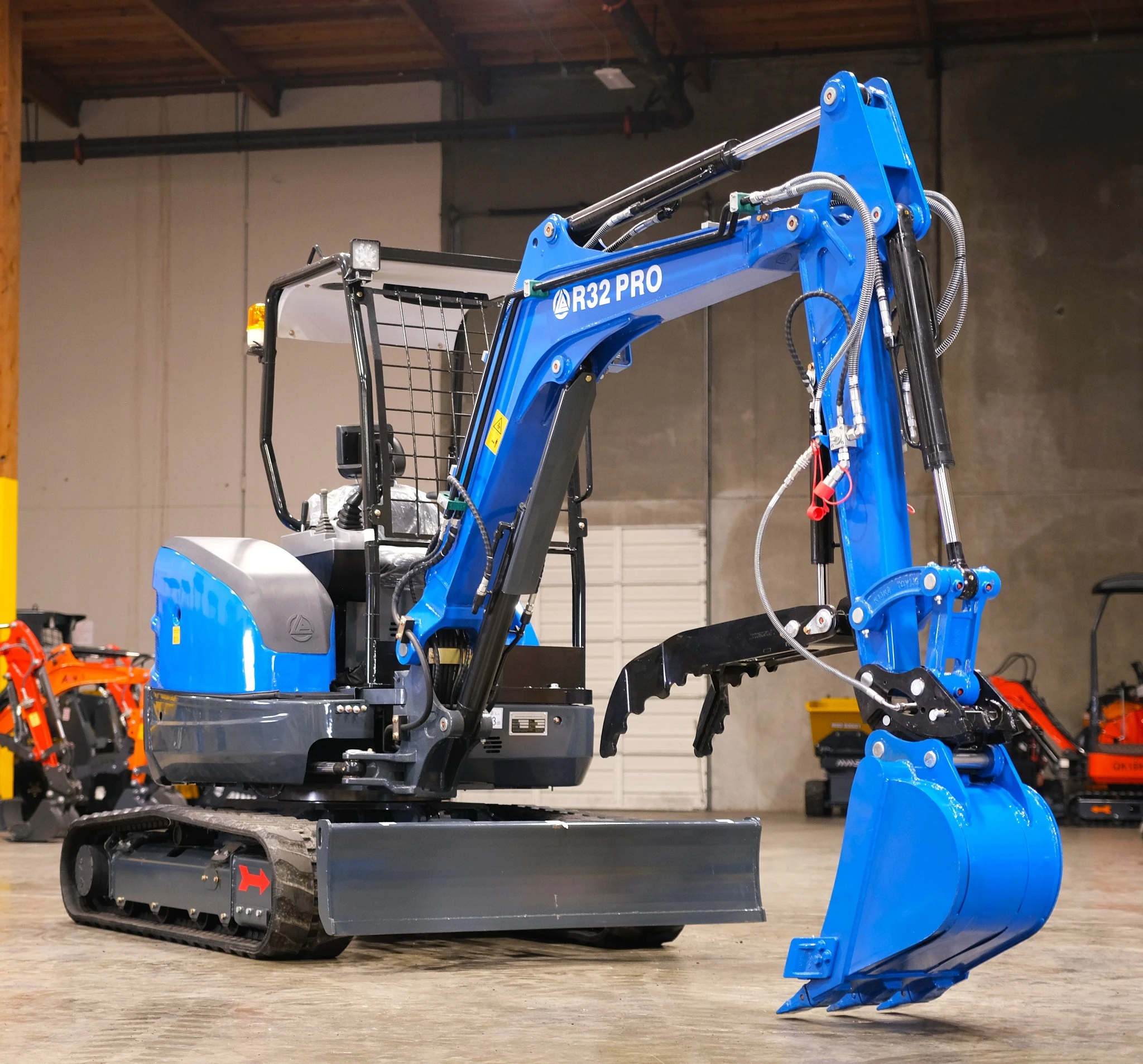 Left-front view of R32 Pro with bucket, dozer blade and ROPS.