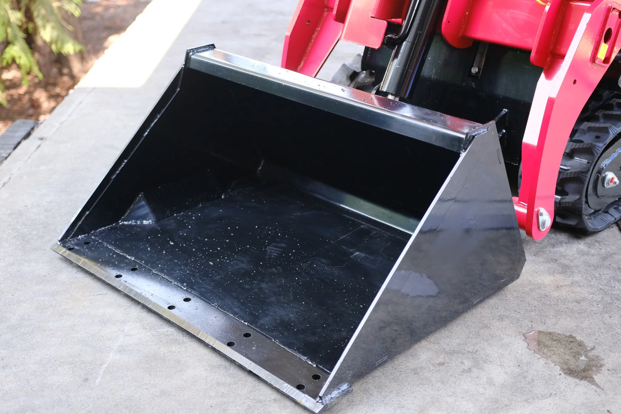 Close-up of the 39-inch general-purpose bucket installed on the SDLOOL SL-V1000 mini skid steer loader.