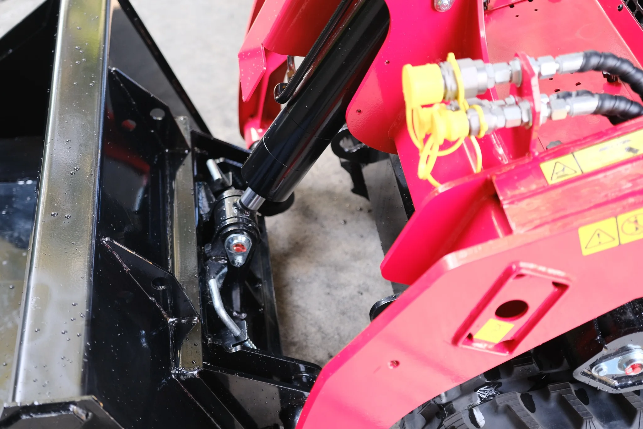 Hydraulic bucket tilt cylinder and attachment linkage on the SDLOOL SL-V1000 mini skid steer loader.