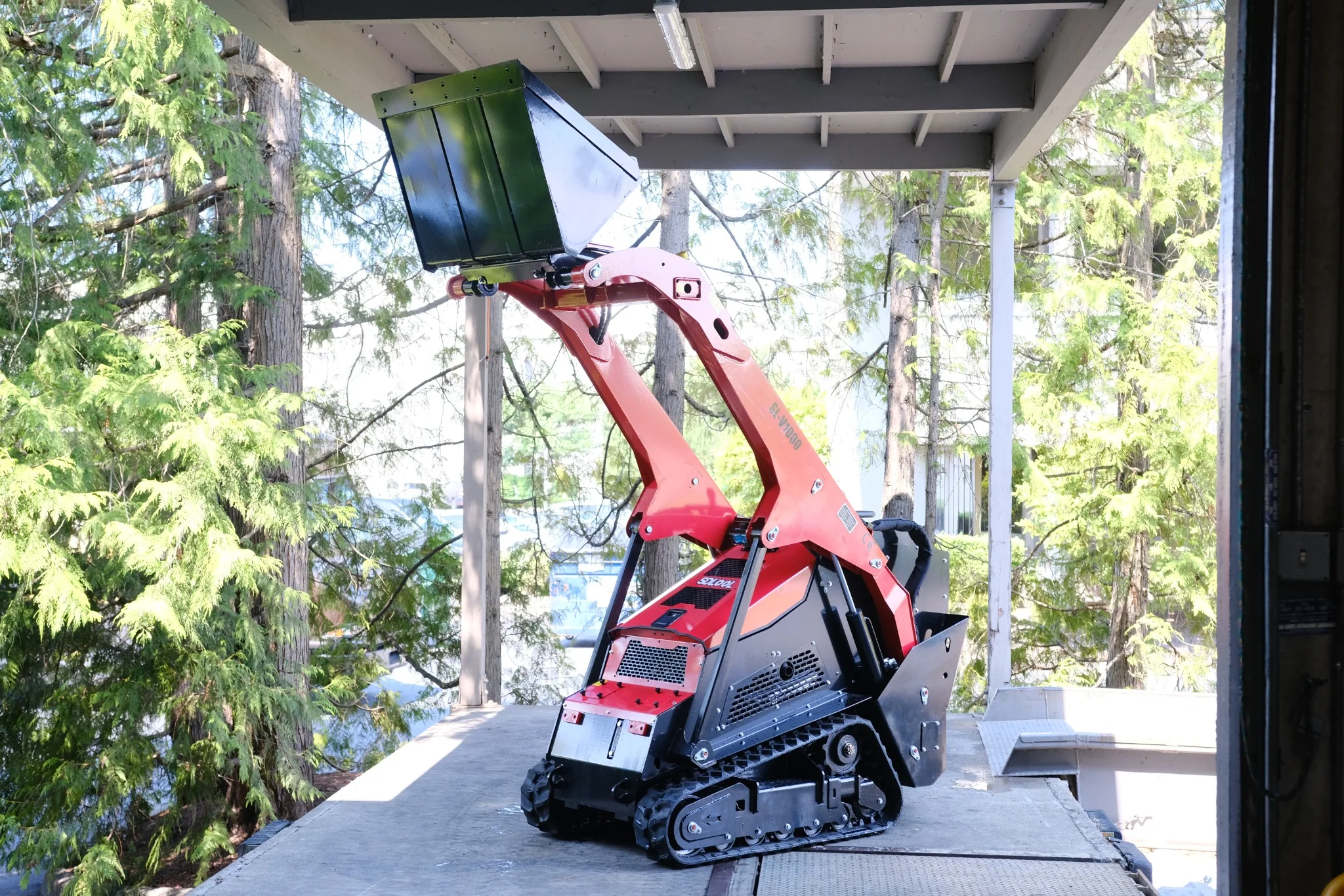 Side front view of the SDLOOL SL-V1000 with loader arms fully raised.