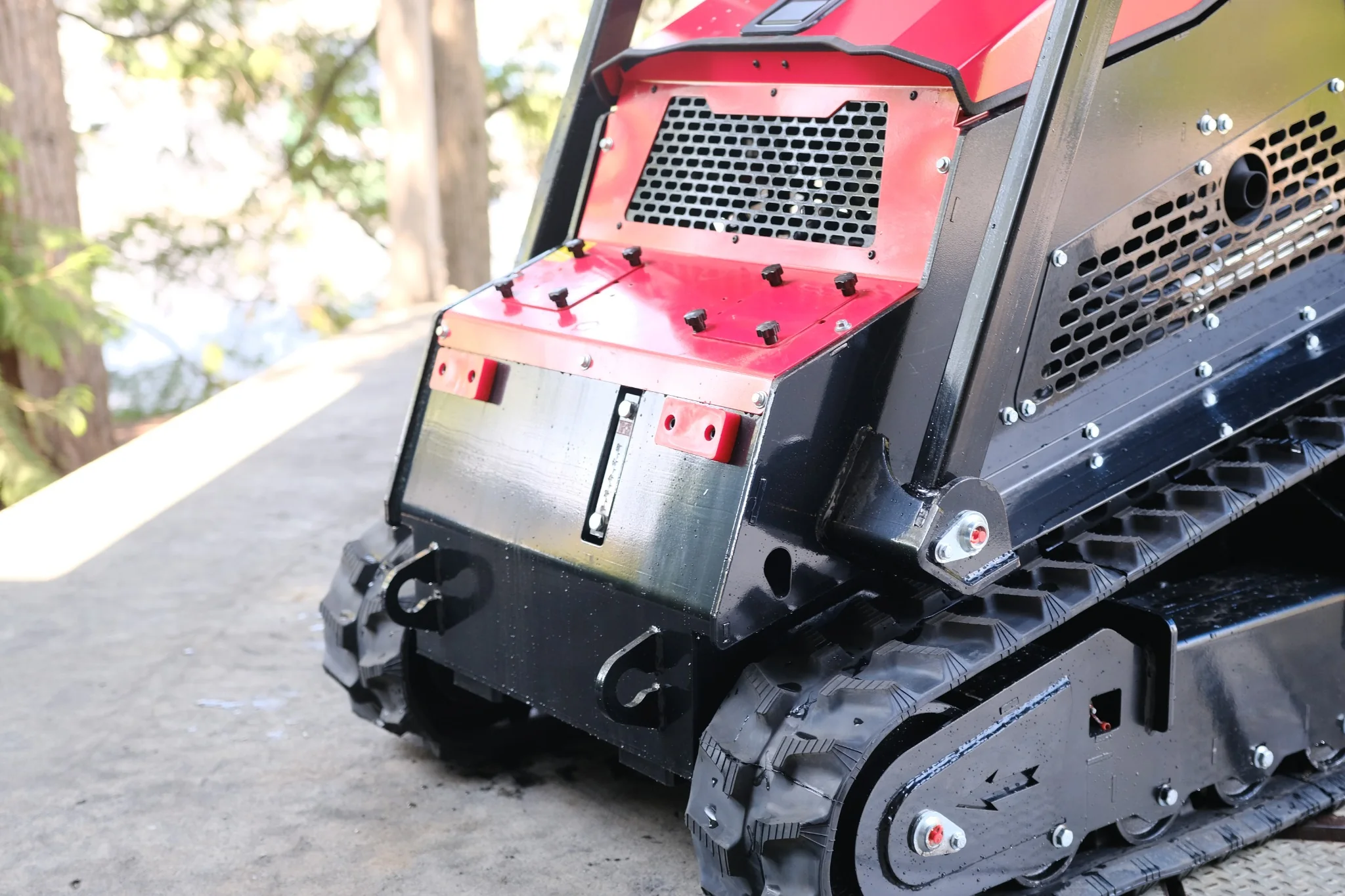 Front body panels, ventilation grilles, and tracked undercarriage of the SDLOOL SL-V1000 mini skid steer loader. Hydraulic gauge.