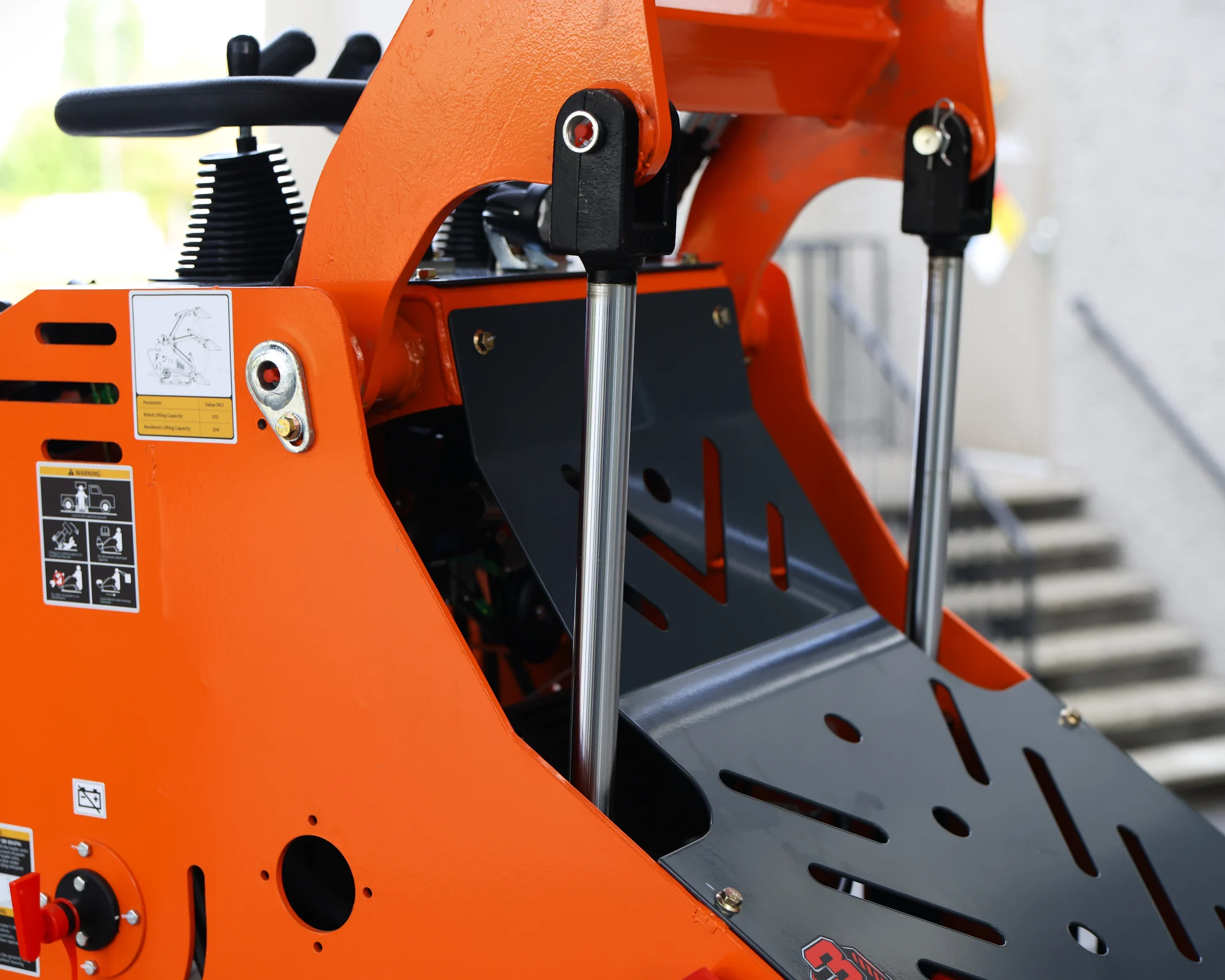 Dig Master DM24 orange mini skid steer: loader lift cylinders