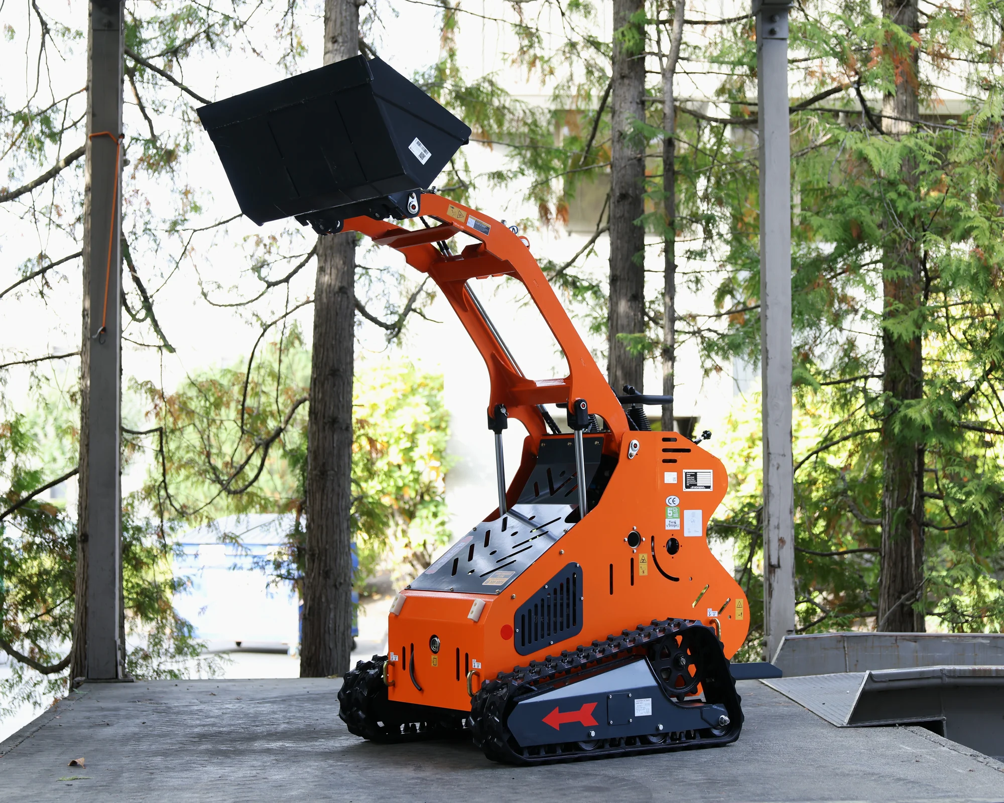 Orange Dig Master DM24 mini skid steer with loader arms and bucket raised